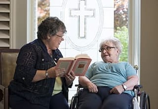 Senior Living Chaplain reading to senior living resident