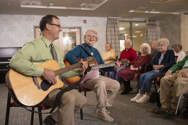 Senior living resident performing for other residents