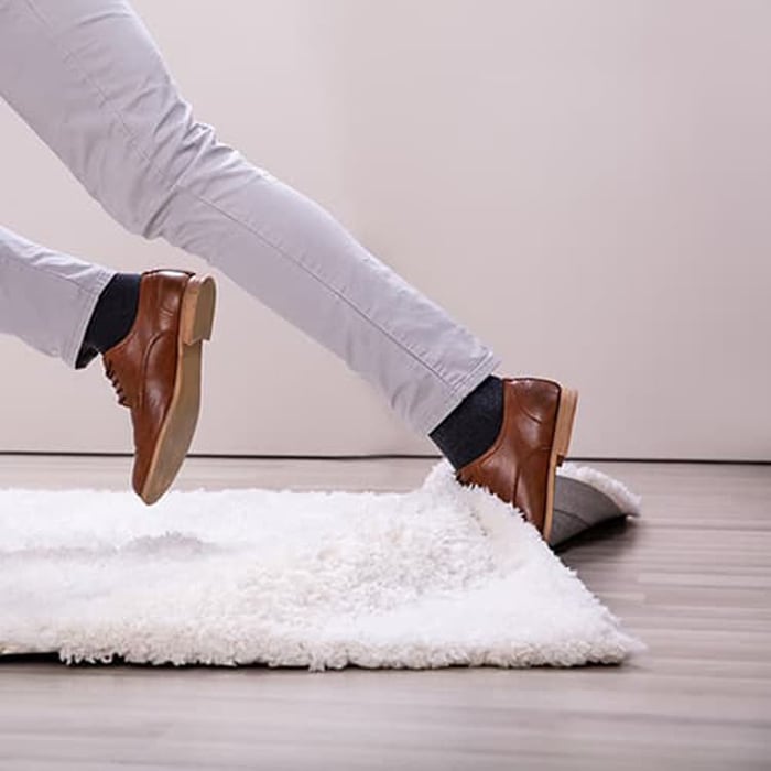 Person tripping over white rug