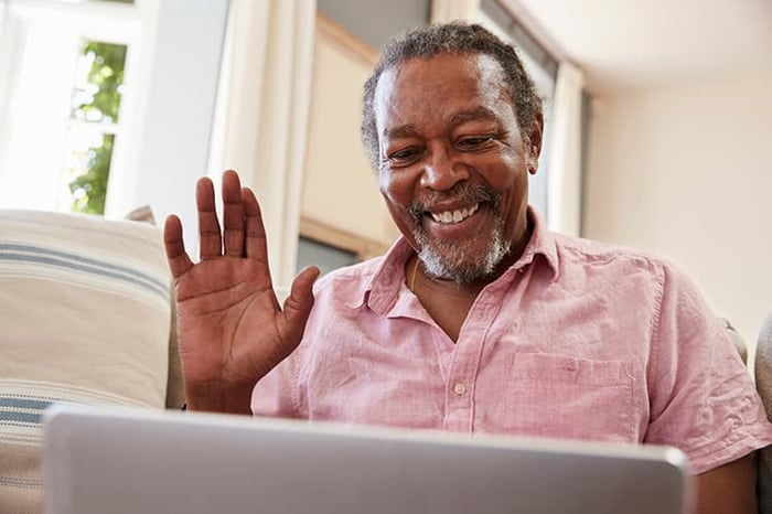 Senior man using tablet to talk to family