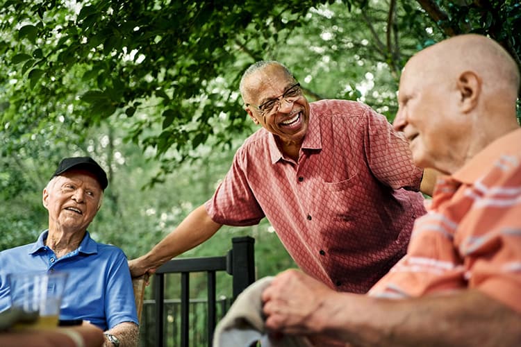 Group of three senior men sitting together, laughing and talking (1)