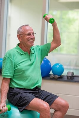 A healthy senior man lifting weights