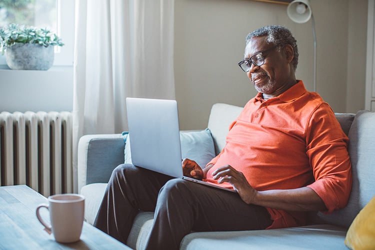 Man with laptop sitting on sofa