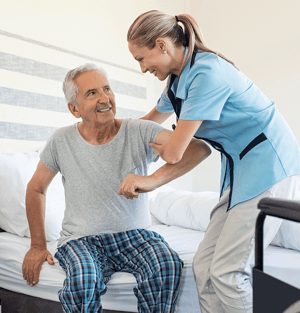 Nursing helping older adult out of bed