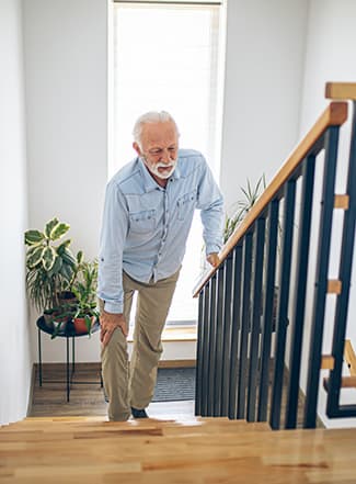 Senior Man climbing stairs in pain