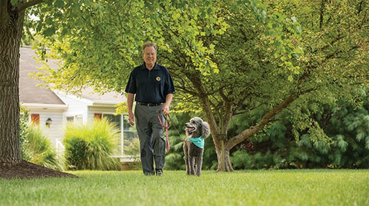 Senior Man walking dog in senior living community