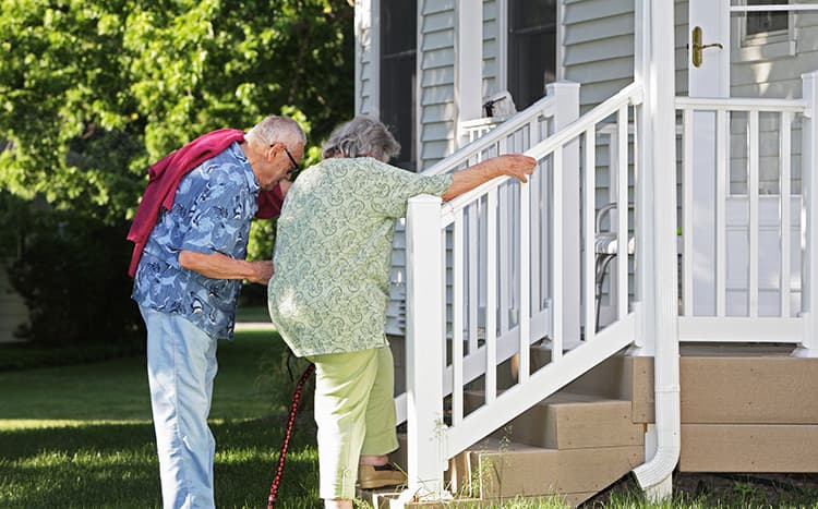 Senior couple on stairs into home
