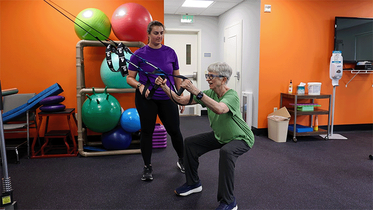 Senior female in gym with senior living team member