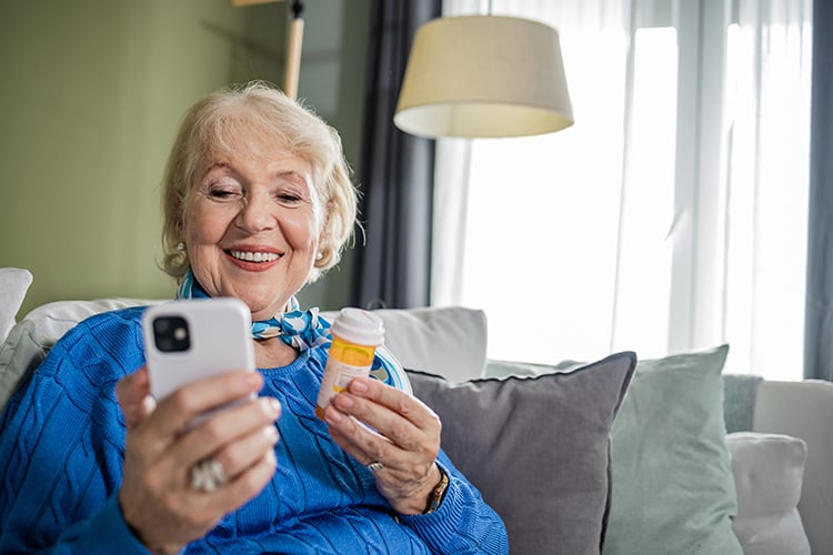 Senior woman with phone for medication reminder