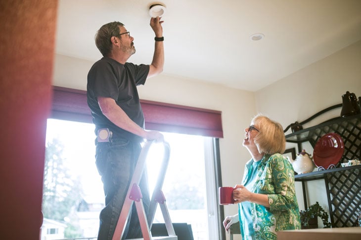maintenance-fixes-lightbulb-for-senior-woman