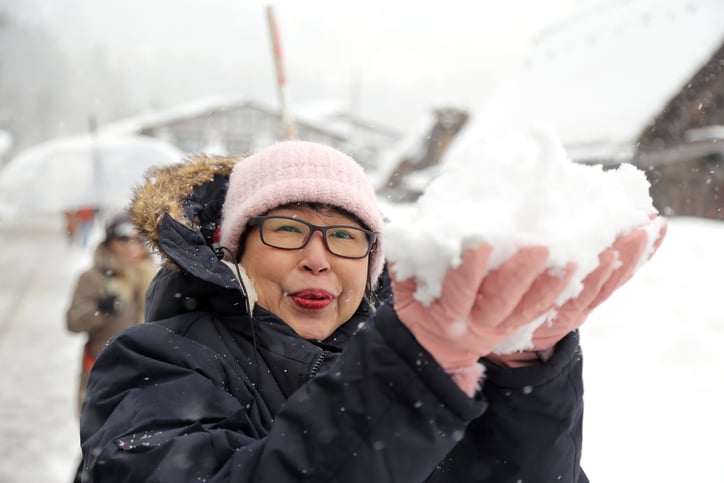 senior woman playing in snow