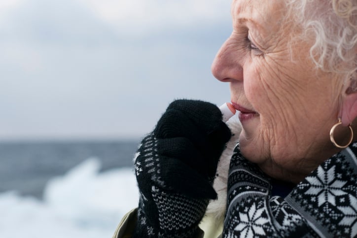 senior woman putting chapstick on in the winter