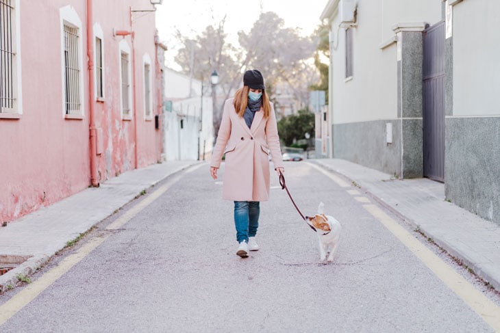 women-walking-her-dog-while-practicing-social-distancing