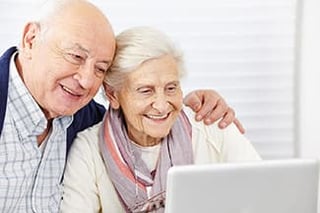 Senior man and woman looking at coputer screen