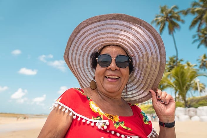 Smiling senior woman with a large sun hat