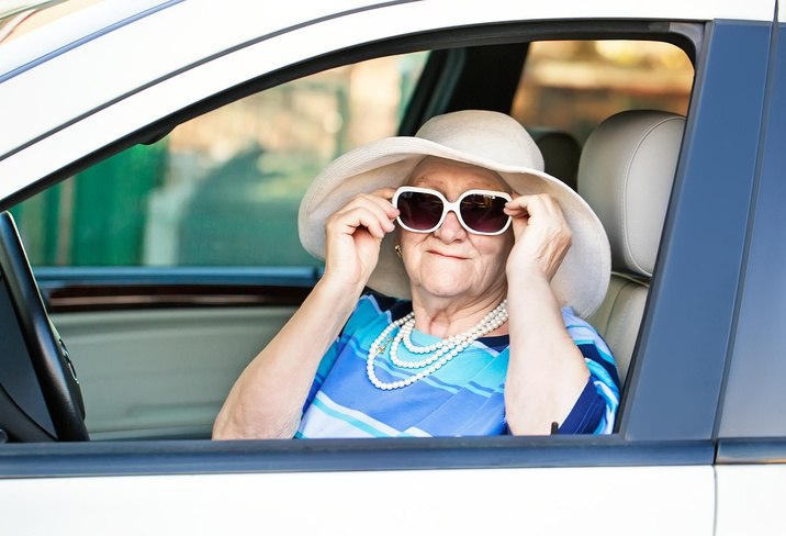 senior wearing sunglasses in car