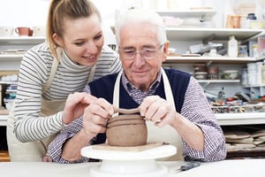 Senior doing pottery with woman