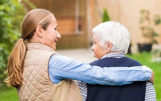 caregiver with arm around senior