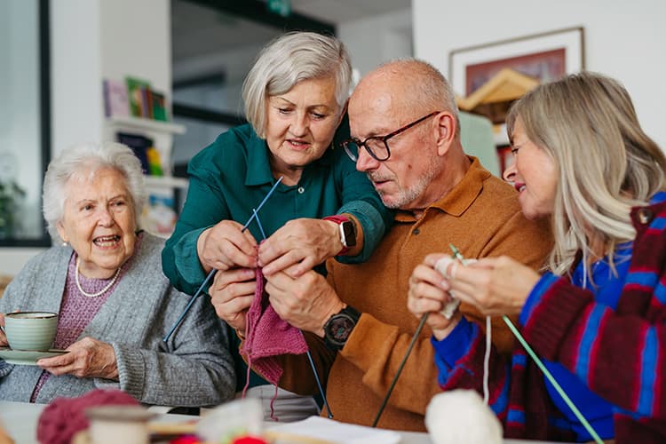 male and female seniors learning to knit