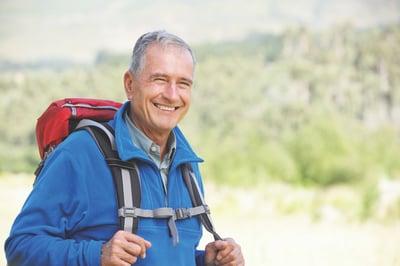 Older man hiking with a backpack on